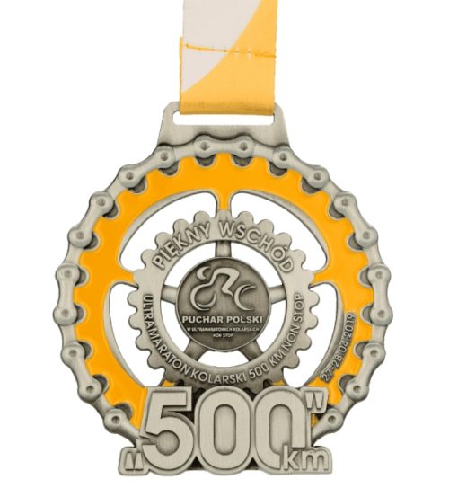 Medal odlewany ultramaraton rowerowy w kształcie zębatki wypełnionej żółtym kolorem
