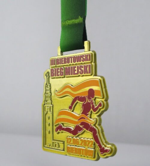 Medal na Bierutowski Bieg Miejski o ciekawym kształcie z trójwymiarowymi zdobieniami w postaci wieży ratusza oraz biegacza w ruchu