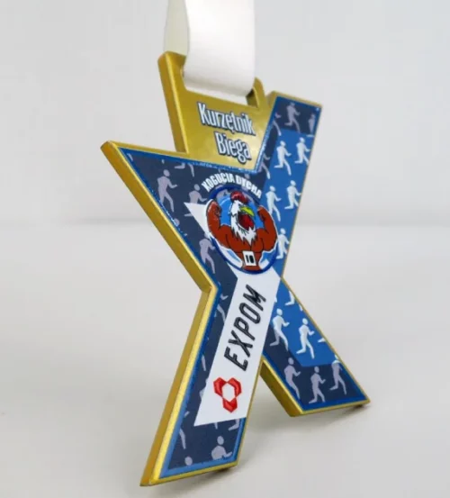 Medal Kogucia Dycha to cięty laserowo medal w kształcie litery X, która symbolizuje dziesiątą edycję biegu
