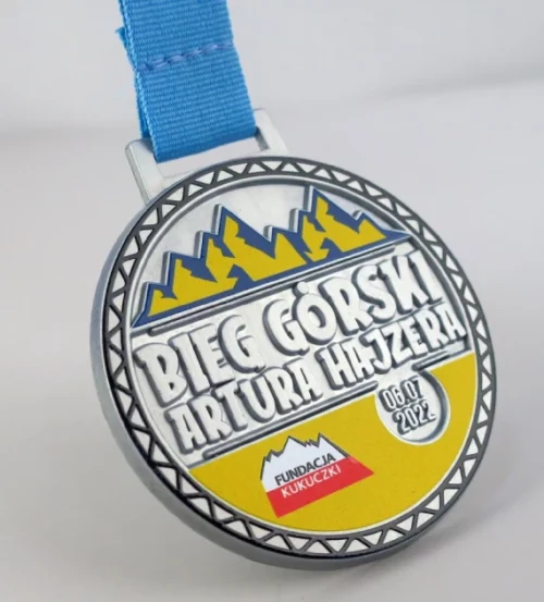 Medal na Bieg Górski Artura Hajzera ma okrągły kształt i trójwymiarowe zdobienia z kolorowym nadrukiem