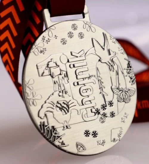 Medal na Chojnik Karkonoski Festiwal Biegowy o okrągłym kształcie z licznymi zdobieniami