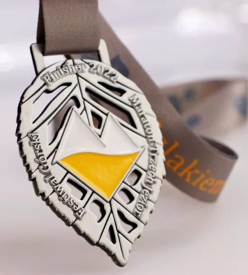 Medal na Maraton Trzech Jezior wykonany w kształcie liścia z kolorowym logo w centrum - artystyczne