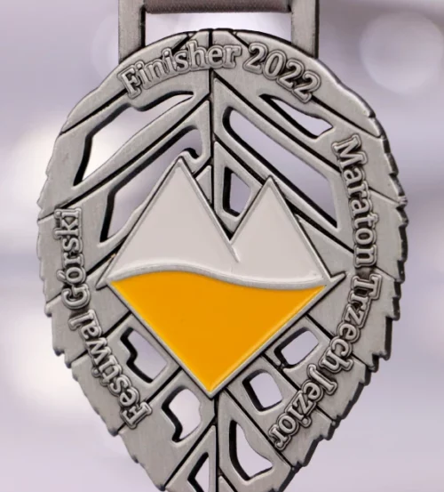 Medal na Maraton Trzech Jezior wykonany w kształcie liścia z kolorowym logo w centrum - detal