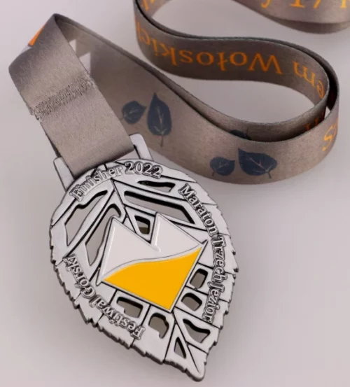 Medal na Maraton Trzech Jezior wykonany w kształcie liścia z kolorowym logo w centrum - wstążka
