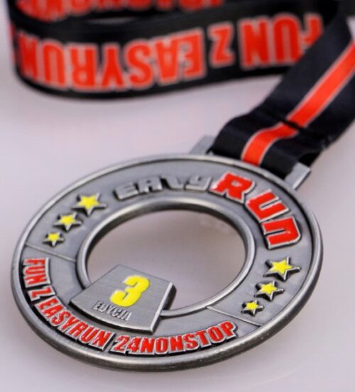 Medal na EasyRun Racibórz ma okrągły kształt z trójwymiarowymi zdobieniami pokrytymi kolorową emalią