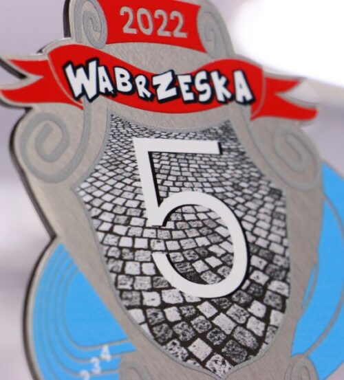 Medal na biegi Wąbrzeska Dziesiątka mają oryginalny kształt oraz kolorowy nadruk - detal 2