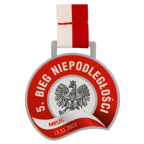 Medal na Bieg Niepodległości Mielec ma ciekawy, zaokrąglony kształt oraz wypełniony jest kolorowym nadrukiem w patriotycznych barwach - przód
